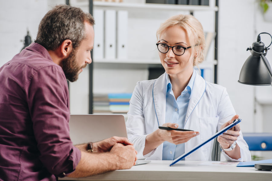 Ärztin spricht mit einem Patienten