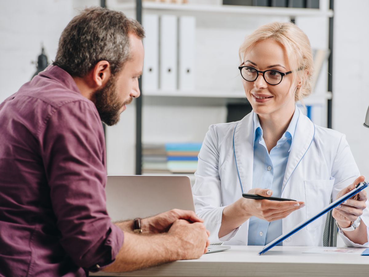 Ärztin spricht mit einem Patienten