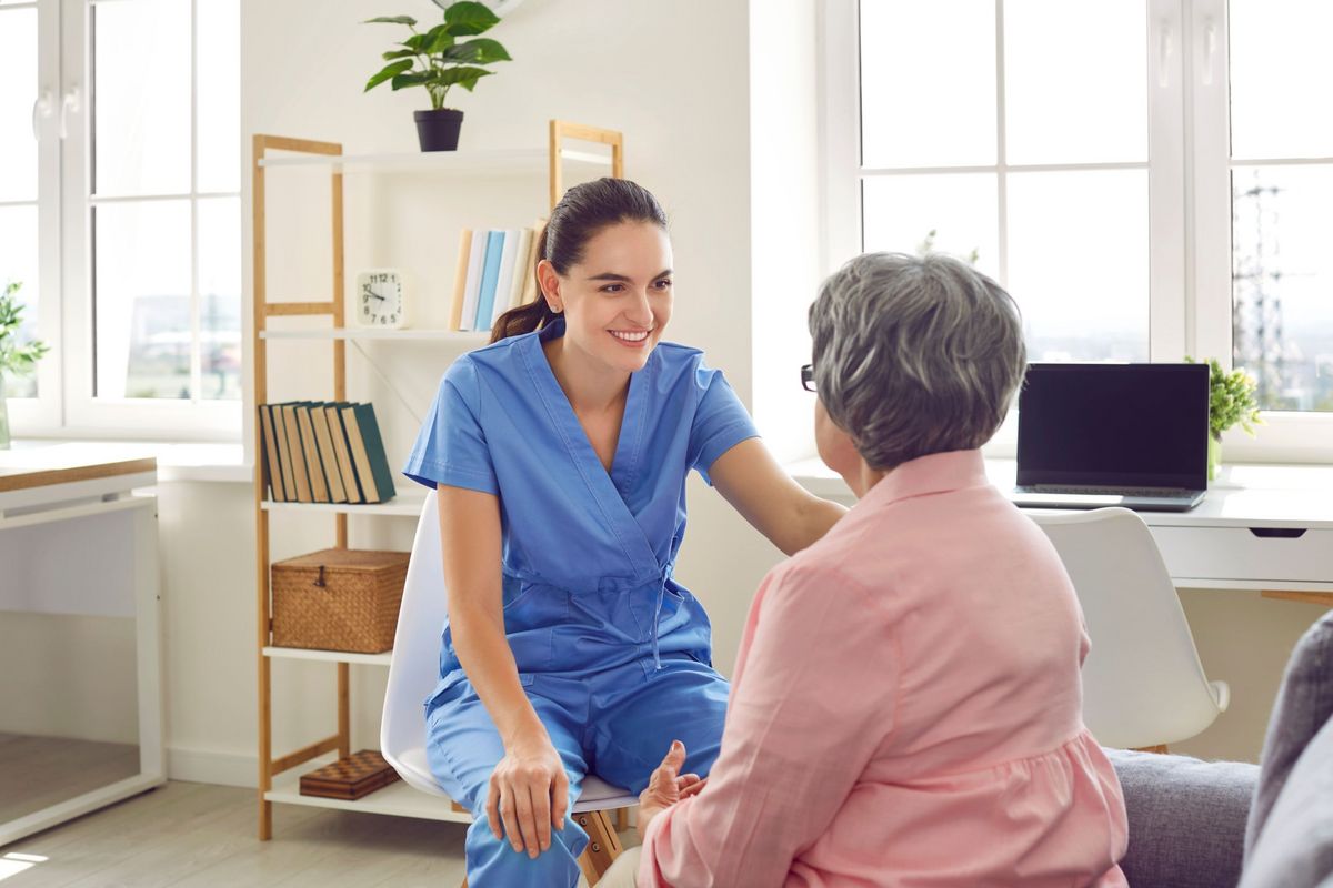 Junge Ärztin im Gespräch mit einer älteren Patientin